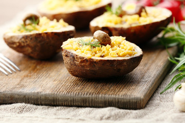 Baked potatoes with cheese and mushrooms on table close up