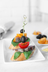 Tasty canapes on wooden table, close up