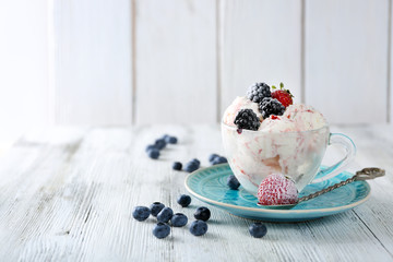 Delicious ice cream with fresh frozen berries, on color wooden background