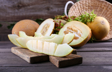 Ripe melons with green leaves on table close up