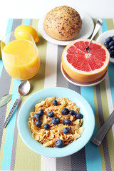 Tasty cornflakes with fruits and berries on table close up
