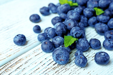 Fresh blueberries with mint on wooden table close up