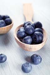 Fresh blueberries in spoon on wooden table close up