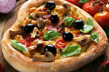 Heart shaped pizza on cutting board closeup