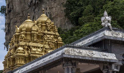 The roof of an ornate, golden Hindu temple, with Hanuman, the Hindu monkey god, in the foreground  © parkerspics