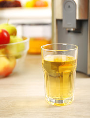 Juicer and apple juice on kitchen table
