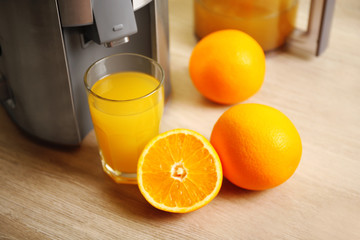 Juicer and orange juice on kitchen table