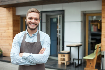 Fototapeta premium Attractive male owner of cafeteria is waiting for customers