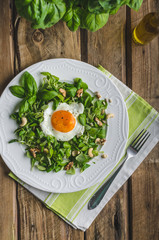 Fresh salad with nuts, raisins and fried egg