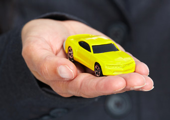 Hand with a yellow car.