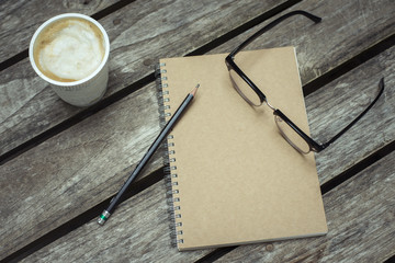 Vintage of Paper notebook and eyeglasses on wood background,Sele