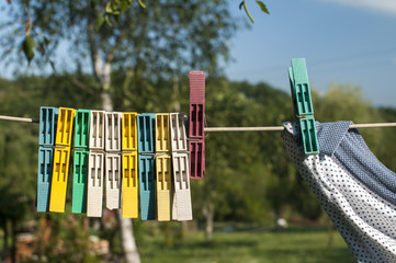 Colored plastic clothesline laundry clips hanging on rope