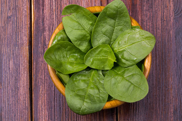 Spinach in a bamboo plate on old boards