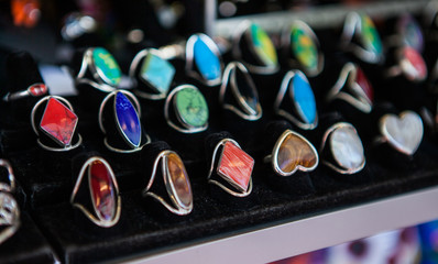 Closeup of hand made rings with colorful stones on market