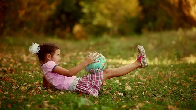 teen  girl brunette sitting on green grass playing studying Glob