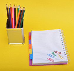 Colorful pencils with notebook & paper pins