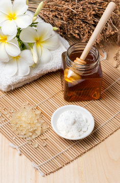 Herbal salt scrub and honey on wood background