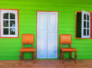 Fototapeta premium Green house with chairs on porch
