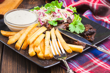 Kebab of beef with french fries and salad