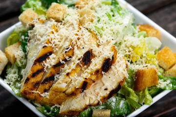 Close Up Caesar salad with chicken and lettuce on wooden table - obrazy, fototapety, plakaty