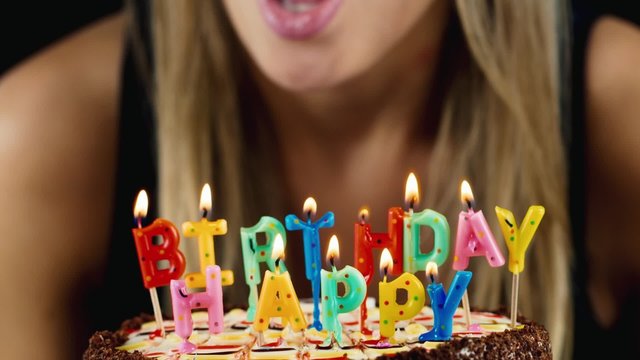 Girl blows out the candles on the cake, smiles