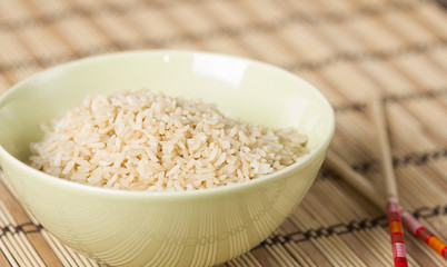 Boiled brown rice on bamboo washer with chopsticks