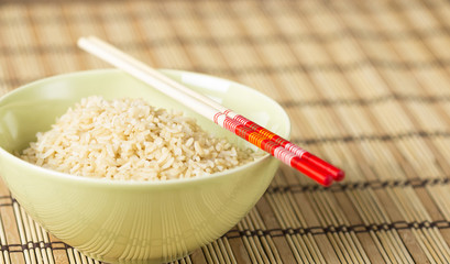 Boiled brown rice on bamboo washer with chopsticks