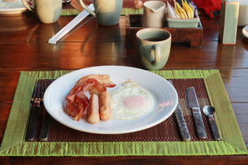 English breakfast with fried eggs, bacon, sausages.