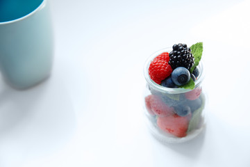 Berries with mint leaves in transparent jar top view