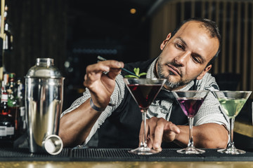 Barman is making cocktail at night club