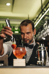 Barman is making cocktail at night club
