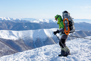 Naklejka na ściany i meble Backpacker woman is walking in winter mountains on sunny day
