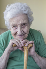 happy senior woman leaning on wooden cane
