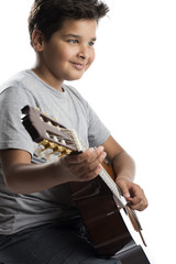 Child on chair playing classical guitar isolated on white background.