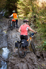 Bikers travel in difficult conditions in autumn forest