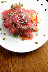 Fine dining, Beef carpaccio with pesto genovese, parmesan cheese, capers and rocket salad