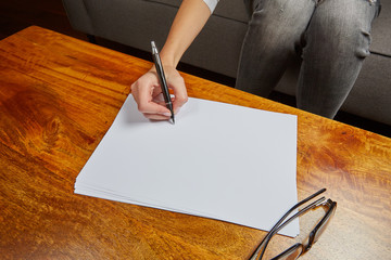 Woman writing on a sheet of papaer - 92781824