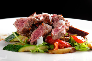 Grilled sliced roast beef on potato and salad