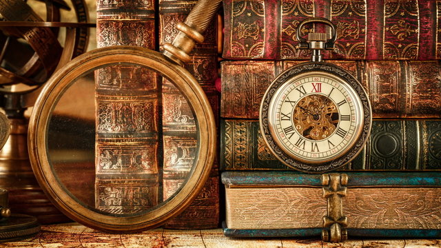 Vintage antique pocket watch against the background of old books