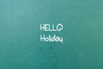Fototapeta na wymiar Green blackboard wall texture with a word Hello Holiday