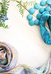 female beauty wearings ornamental background vertical, azure bright colors, beads silk headscarf,flower, empty wooden middle space, soft light, soft focus