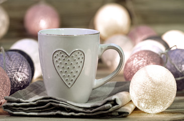 Cup with heart in a warm atmosphere with lights