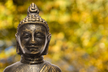 Buddha mit Herbstlaub in gelb und orange