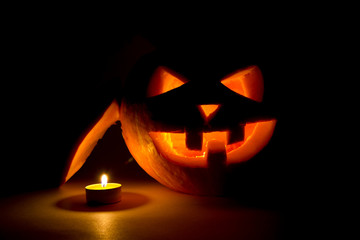 halloween pumpkin jack  lantern with candle on dark