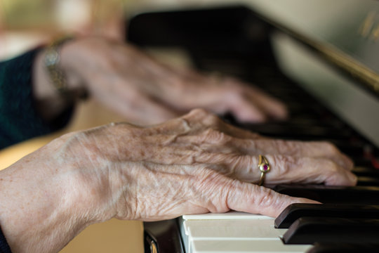 Seniorin macht Fingerübungen am Klavier als Prophylaxe 