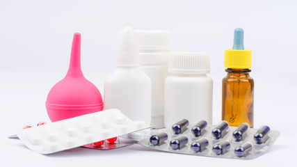 Enema and pills in blister packs with bottles of medicine