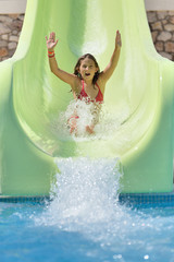 Girl rides on the water slide in a water park.