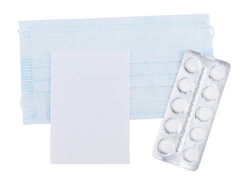 Medical mask and tablets with a white sheet of paper