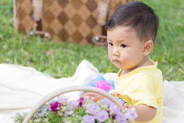 Smiling asian boy toddler sit on white  Cotton in the green gras
