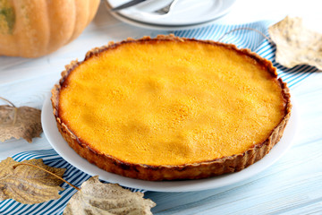 Tasty pumpkin pie on a blue wooden table
